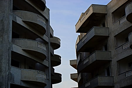 2 Brown High Rise Building Facing Each Other at Daytime thumbnail