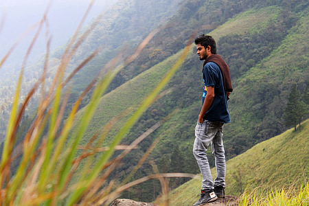 man wearing blue shirt on rock formation thumbnail