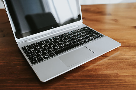 Silver laptop with various items on a table thumbnail