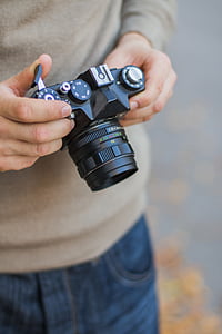 person holding black Zenit DSLR camera thumbnail