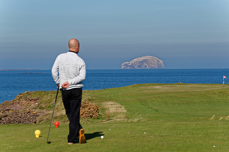 man standing on golf flied thumbnail