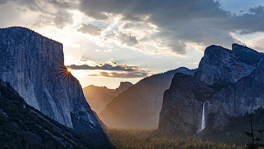 mountain with waterfalls under cloudy sky thumbnail