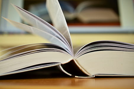 opened book on brown wooden surface thumbnail