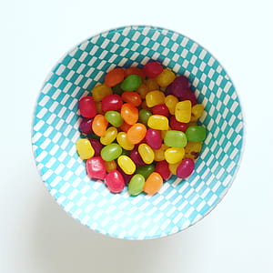 yellow, red, and green candies on round white and green checkered bowl thumbnail