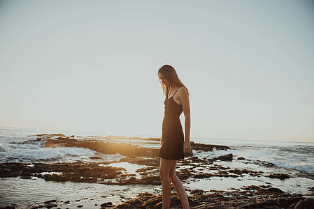 golden hour photography of woman walking in beach thumbnail