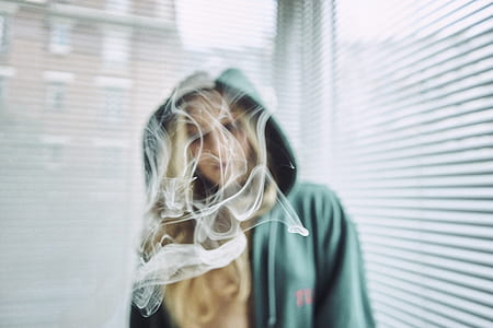 woman standing near window with Venetian blinds thumbnail
