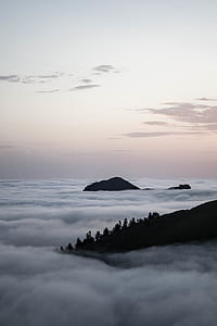 silhouette of mountain covered by white clouds thumbnail