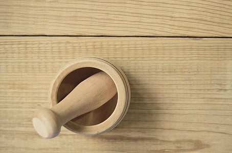 wooden mortar and pestle on wooden surface thumbnail