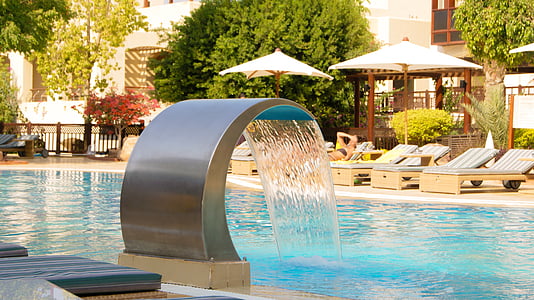 water fountain on pool near green leaf trees thumbnail