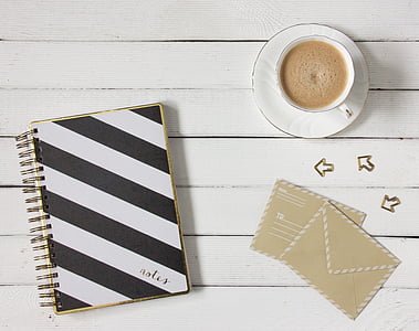 white and black striped notebook and white ceramic tea cup and saucer set thumbnail