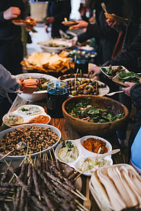 People by a banquet table full with food thumbnail