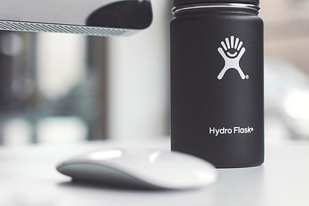 black Hydro Flask tumbler near Apple Magic Mouse thumbnail