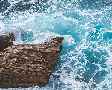 sea waves crashing against brown rock thumbnail