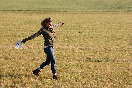 woman in brown hoodie running on field during daytime thumbnail