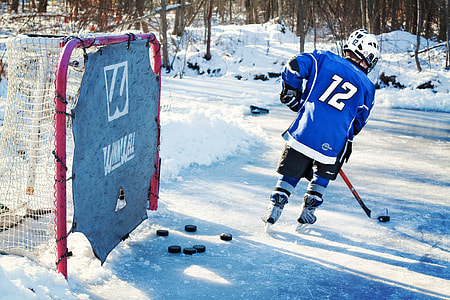 person playing ice hockey near goal thumbnail