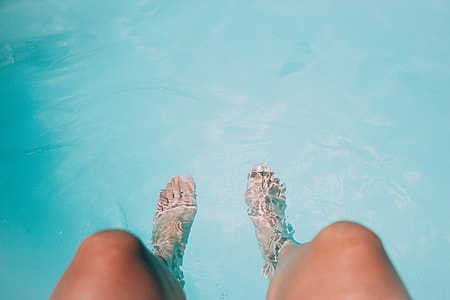 person's feet on body of water thumbnail