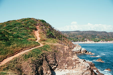 Hikers on the seaside mountain path with a beach in the background thumbnail