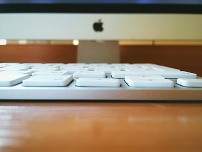 White Computer Keyboard on Brown Wooden Table thumbnail