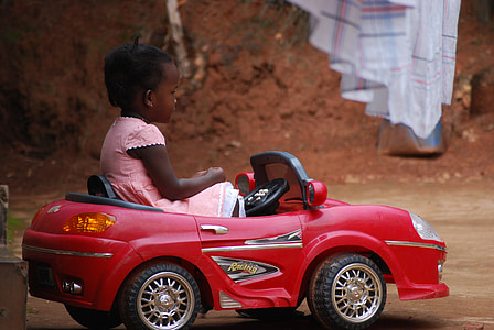 toddler sitting inside red and black ride-on toy car thumbnail