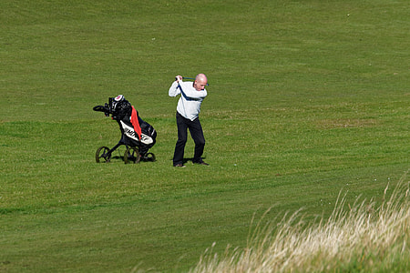 person playing golf on green field thumbnail