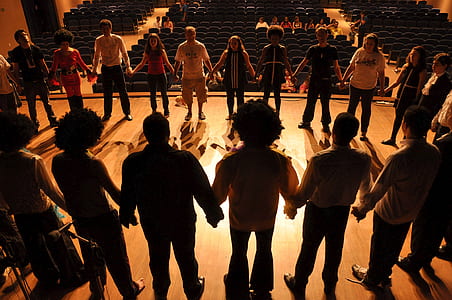 people holding hands forming circle on stage thumbnail