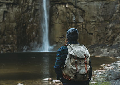 person standing facing waterfalls thumbnail