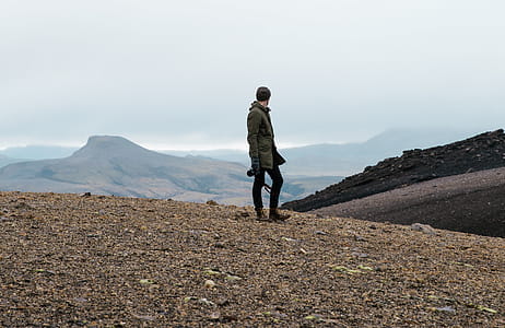 A hiker carrying a camera in rocky Iceland field thumbnail