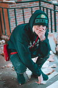 person in black hooded jacket kneeling thumbnail