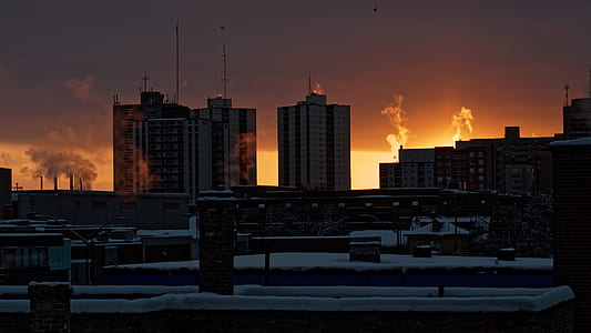 brown high rise buildings city skyline under orange sky thumbnail