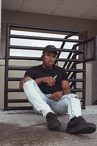 Man Sitting Near Black Railings thumbnail