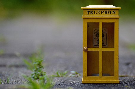 selective focus photography of yellow telephone booth miniature thumbnail