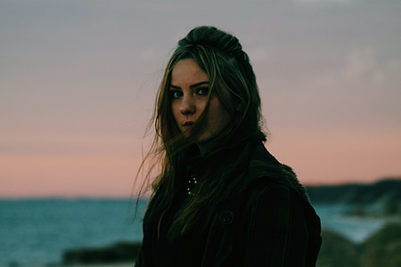 selective focus photography of woman in black jacket near sea thumbnail