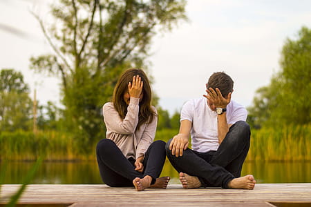 Man and Woman Holding Forehead Sittin on Bridge thumbnail