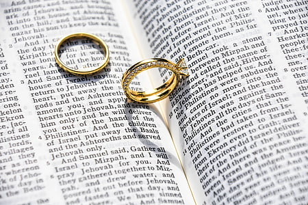 gold-colored wedding band on book thumbnail