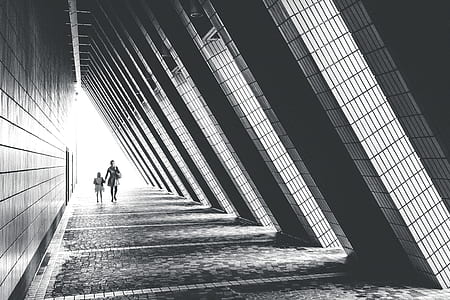 grayscale photography of man and boy walking in building thumbnail