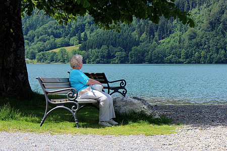 woman sitting on gray metal bench chair near trees thumbnail