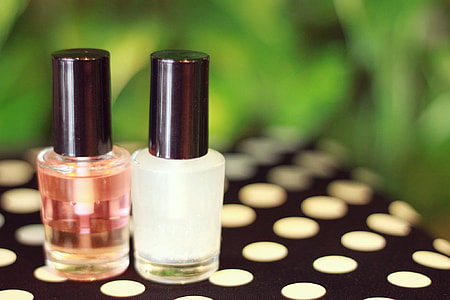 two nail polishes on black and white polka dot surface thumbnail