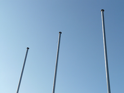three white metal posts under blue sky thumbnail