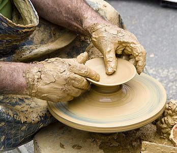 person shaping brown clay thumbnail