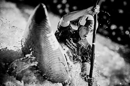 man kayaking on rough water in grayscale photography thumbnail