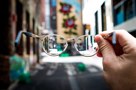 person holding eyeglasses with silver frames thumbnail
