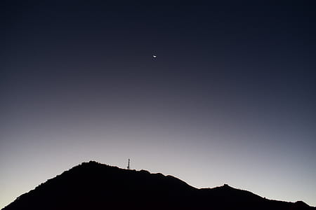 half-moon above silhouette of mountain thumbnail
