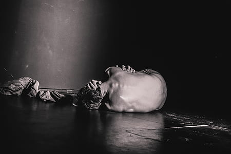 grayscale photography of topless man lying on floor thumbnail