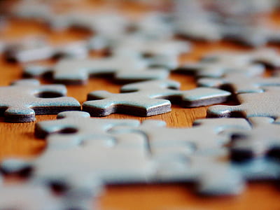 close-up photography of gray puzzles on brown surface thumbnail