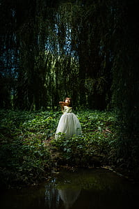 girl in green sleeveless dress standing in the middle of the garden thumbnail