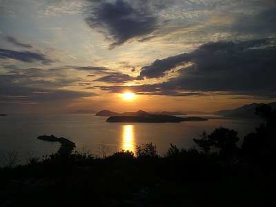 body of water near island at sunset thumbnail
