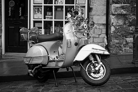 grayscale photo of motor scooter parked near house thumbnail