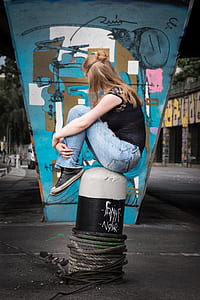 woman sitting on concrete column thumbnail