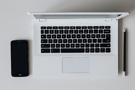White laptop with smartphone and headphones thumbnail