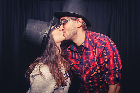 man kissing woman wearing black hats thumbnail